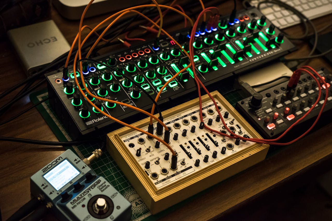 A detailed view of synthesizers and equipment with vibrant lights in a music studio.
